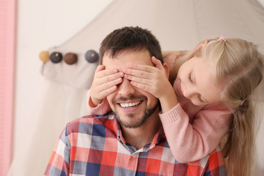 Cute Girl Covering Her Father's Eyes With Hands