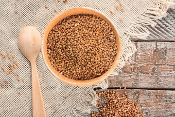 Bowl with raw buckwheat on table
