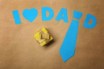 Composition with phrase I LOVE DAD and gift for Father's Day on craft paper