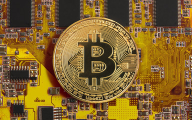 bitcoin concept - gold coin, computer circuit Board with bitcoin processor and microchips....