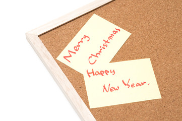 Merry christmas writen on yellow sheet, cork board