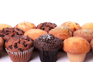 Muffin cup cake or cupcake several different various flavors in a row line border group isolated on white background photo
