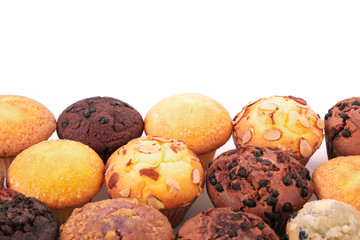 Muffin cup cake or cupcake several different various flavors in a row line border group isolated on white background photo