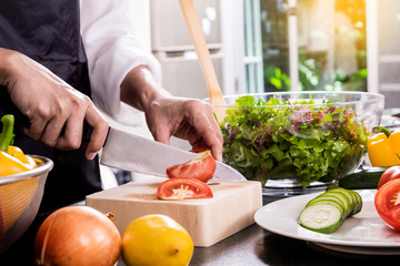 Healthy Woman makes fresh vegetable salad with olive oil, tomato and salad.