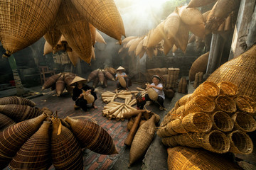 Group of Old Vietnamese female craftsman making the traditional bamboo fish trap or weave at the...