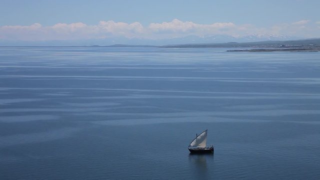 Sailboat floats in the sea or ocean, an old style ship on the water