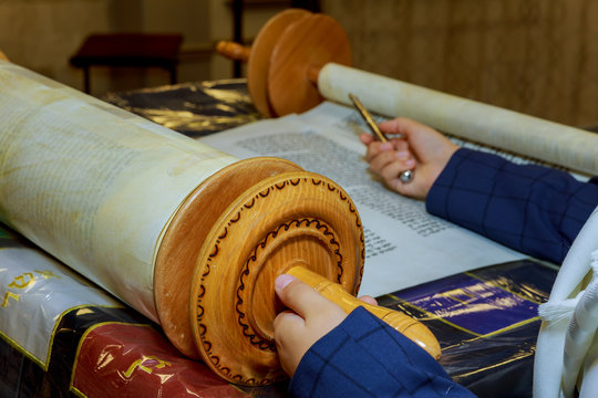 Reading a Torah scroll during a bar mitzvah ceremony .