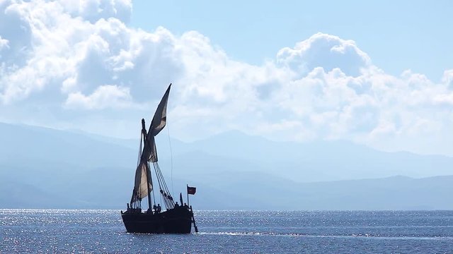 Sailboat floats in the sea or ocean, an old style ship on the water
