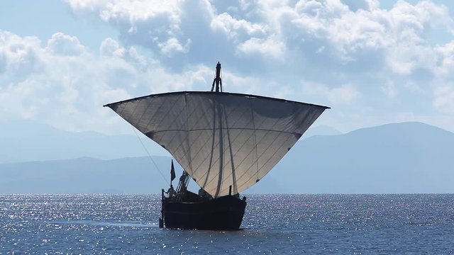 Sailboat floats in the sea or ocean, an old style ship on the water