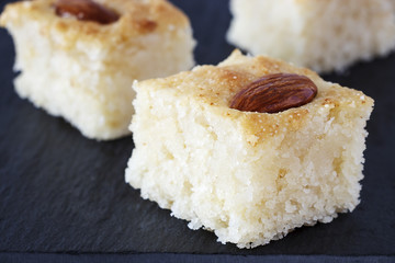Closeup Three Pieces Basbousa Traditional Arabic Semolina Cake with Almond Nuts Orange Blossom...