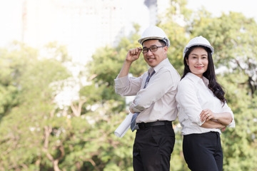 asian men and women engineers work on plans construction  in the park