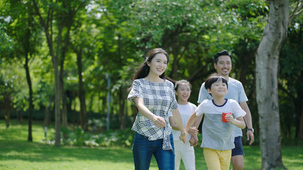 Naklejka na ściany i meble Chinese family smiling & walking together in park