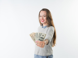 Cheerful pretty young woman holding dollars cash and happy smiling to the camera isolated on white background