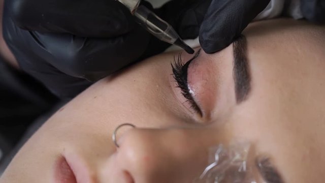 Beautician, specialist of permanent make-up making eyeliner permanent make up