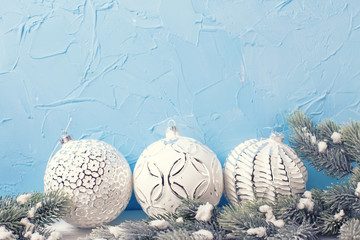 Three white balls  and fur tree spruces against  blue wall.