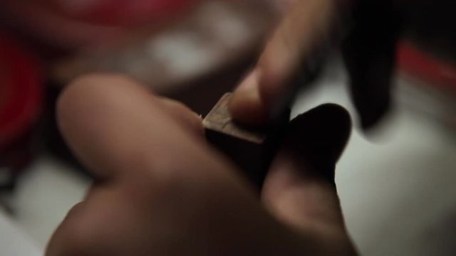 A Craftsman is making traditional chinese wooden stamp or seal, closeup detail his hands and tool
