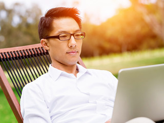 Fototapeta premium Young businessman relaxing during her break in park