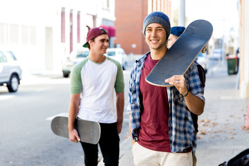 Teenager boy walking at the street with his skateboard