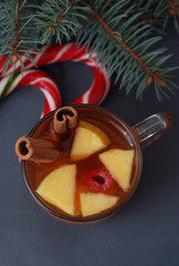 Hot Winter Tea with Fruits - apple, cinnamon, anise. On Dark marble table. Cristmas Candy, Fir Branches. Ttop view
