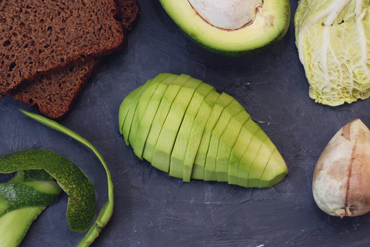 Sliced ripe avocados on Dark cutting board. Vegan and Health Food Concept