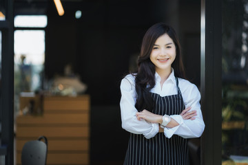 Portrait of smiling barista with arms crossed