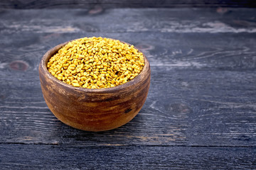Fenugreek in clay bowl on board