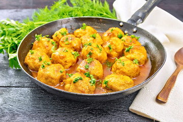Meatballs in pan with greens on board