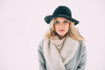Fototapeta premium Beautiful winter portrait of young woman in the winter snowy scenery.