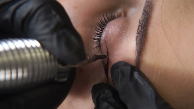 Beautician, specialist of permanent make-up making eyeliner permanent make up