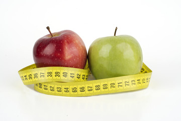 Green and red apple with measuring tape 