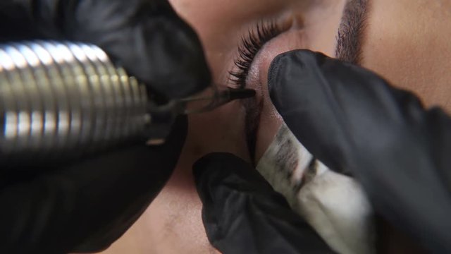 Beautician, specialist of permanent make-up making eyeliner permanent make up