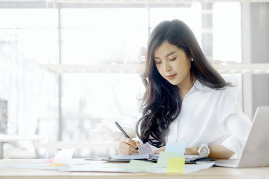 Cropped shot of an attractive young businesswoman working on document and laptop in her office.