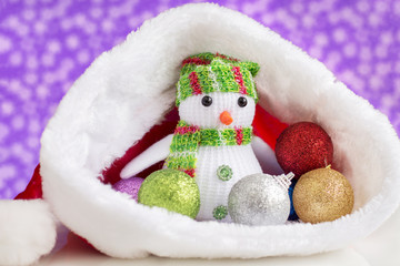 snowman, with toy balls for the Christmas tree, in Santa Claus hats