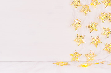 Christmas blank interior with glow lights golden stars on white wood background.