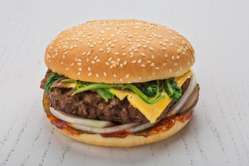 hamburger with meat cutlet, pickle, onion, cheese, spinach and spicy sauce