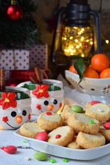 Christmas and new year holiday celebration concept background. Mug of mulled wine with spices, homemade nut cookie, shortbread, xmas tree decoration on wooden table