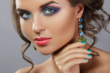 Woman with a beautiful makeup and hairstyle wearing shiny earrings
