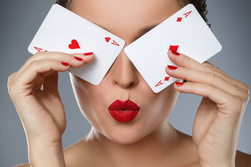 Woman with red lips is holding two aces in her hands