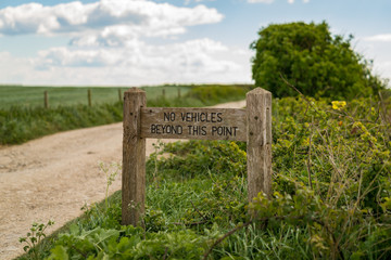 Fototapeta na wymiar Sign: No vehicles beyond this point, with a blurry background, seen near Worth Matravers, Jurassic Coast, Dorset, UK