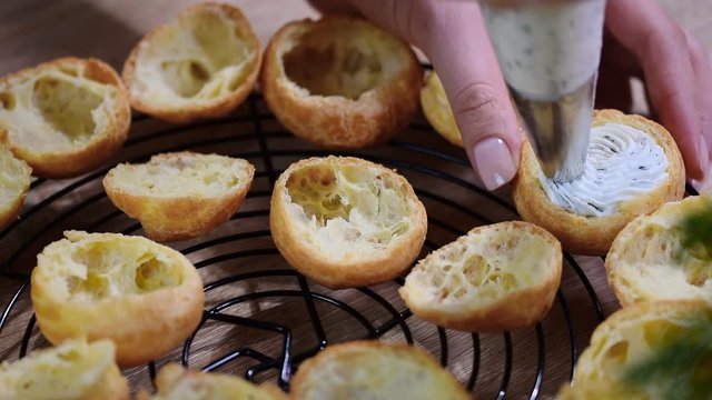 The chef fills the profiteroles cream