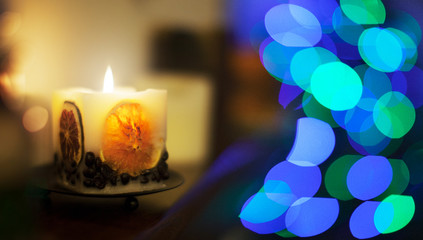 Candela profumata accesa con decorazioni natalizie