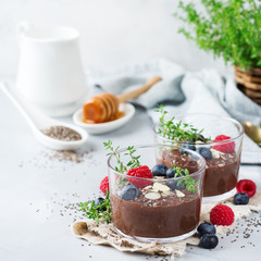 Healthy vegan chocolate chia pudding with berries and green thyme