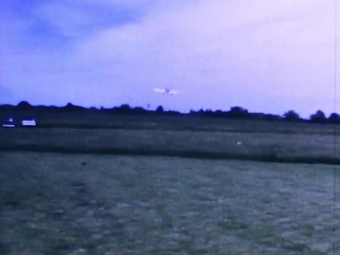 Radio controlled airplane pilot taxis his plane down grassy runway and takes off into the sky for aerobatic maneuvers at the Bridgewater state farm correctional institution in Fall 1967