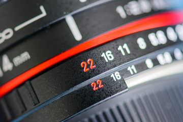 Macro shot of a camera lens focusing on camera lens information the aperture size f 2.8 and ens focal length is 14 mm, point at 22 mm.