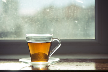 Hot tea cup on a frosty winter day window background