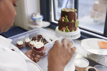 Obraz na płótnie Canvas Black woman preparing food in a bakery, over shoulder view