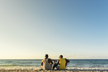 Two cuban friends having fun in the beach with his guitar.