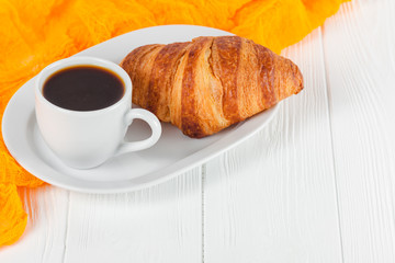 Freshly baked croissant orange juice, jam, cup of black coffee on white wooden background. French breakfast. Fresh pastries for morning. Delicious dessert. Closeup photography. Horizontal banner