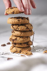 A woman's hand is stealing chocolate chip cookies. Gourmet conception.