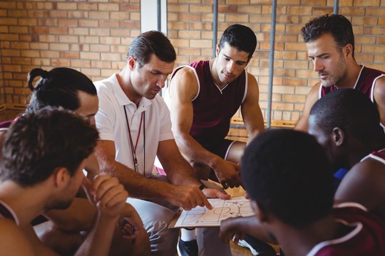 Coach Explaining Game Plan To Basketball Players